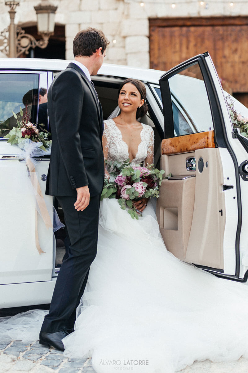 Bride getting out of car, looking at groom